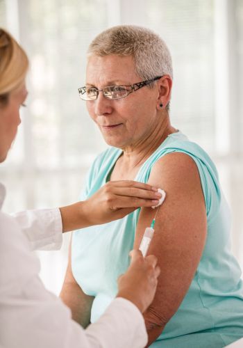 Doctor giving an injection to an older patient